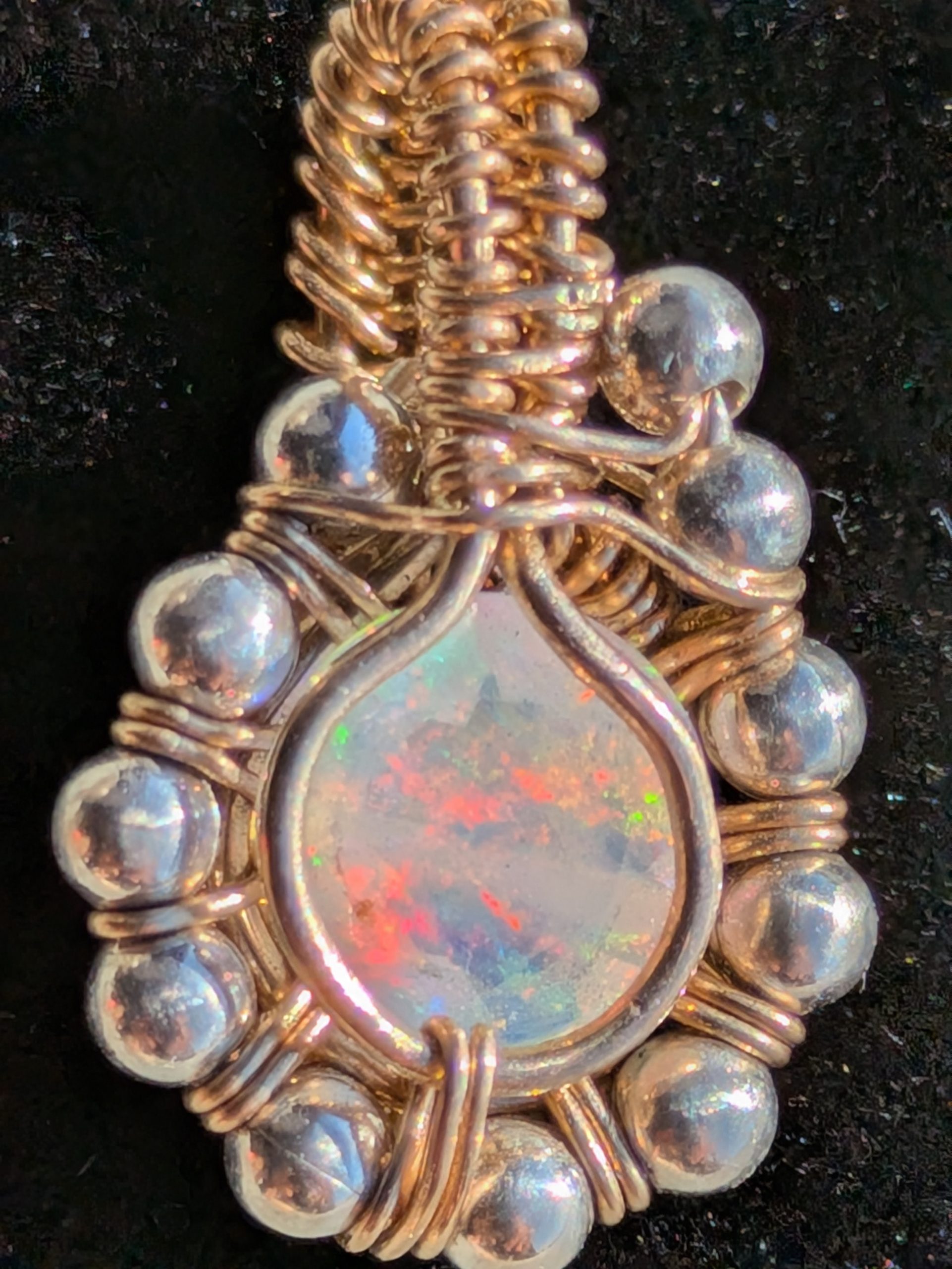 Close-up of Sunlit Facet handmade faceted opal pendant